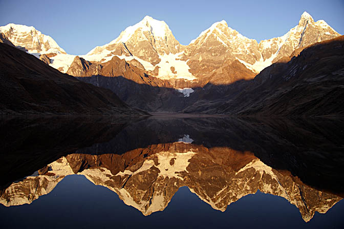 The sunrise red colors on the three peaks of The Great Mount Yerupaja reflected in Lake Carhuacocha, 2008