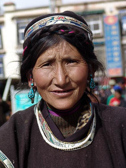 A smiling Tibetan woman on pilgrimage along the Lingkor around the Jokhang, Lhasa, Tibet, China 2004