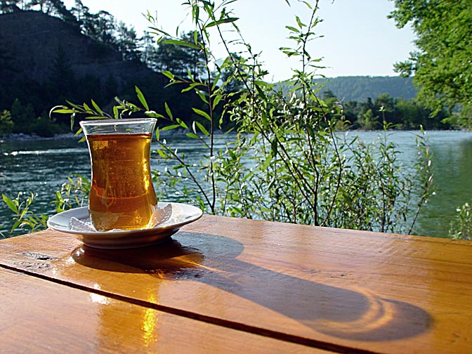 כוס תה, המשקה הלאומי הטורקי, במקום של הוסני על גדות הקופרלו באנטליה, טורקיה 2002