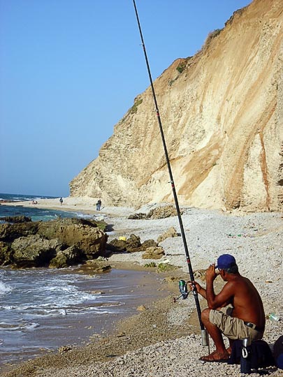 דייג מטיל חכה בחוף הים מצפון להרצליה, שביל ישראל 2003