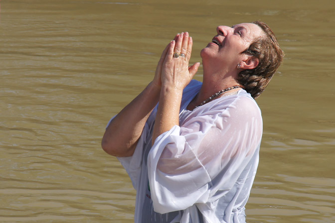 צליינית עולה מן הטבילה בנהר הירדן ומתפללת באדיקות, אתר הטבילה כאסר אליהוד 2012