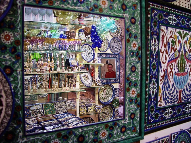 השתקפות של כלי קרמיקה מעוטרים בסגנון ארמני וכלי זכוכית חברונית צבעוניים בשוק, העיר העתיקה 2003