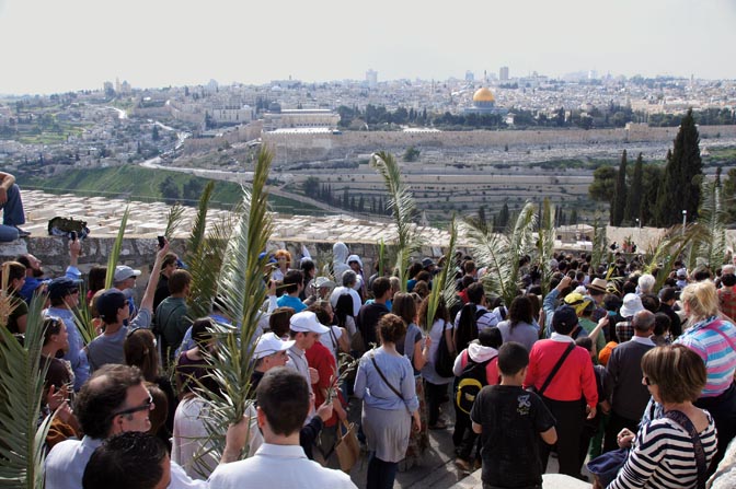 Pilgrims raising palm branches in the Catholic and Protestant procession, descending from the Mount of Olives towards Jerusalem, 2012