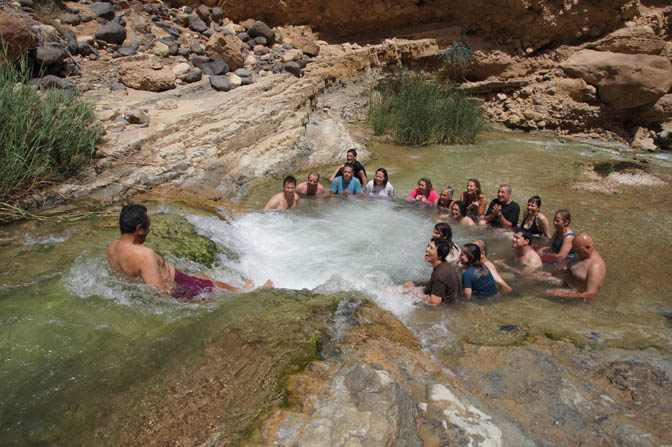 Abdullah slides down the waterfall to the warm pool of Wadi Zarqa Ma‘in, 2012