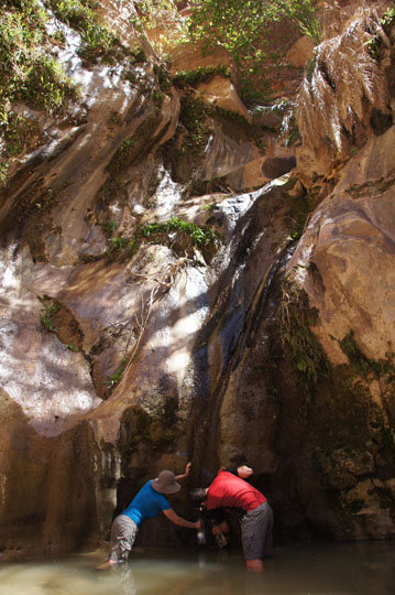 Tanya and Gal filling water bottles from the clear springs bursting from the cliffs of  Wadi Ghweir, 2014