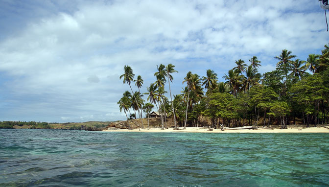Blue transparent water, white sand beach, and coconut palms, Kabuni Village 2009