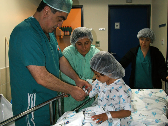 ד''ר סימון מחדיר חומר מטשטש לעירוי התוך ורידי של האורז בדרך אל חדר הניתוח, בית החולים וולפסון 2011