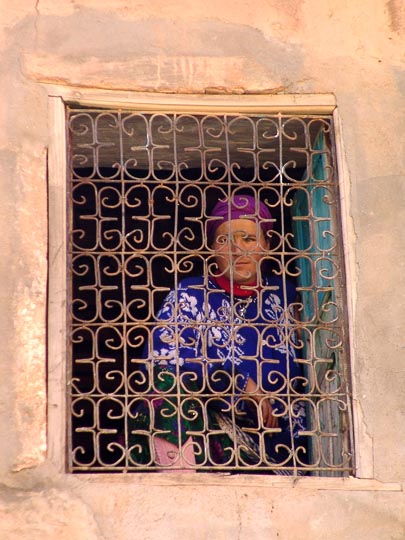 A woman in a Kasbah window with decorative bars, Timichichi village 2007