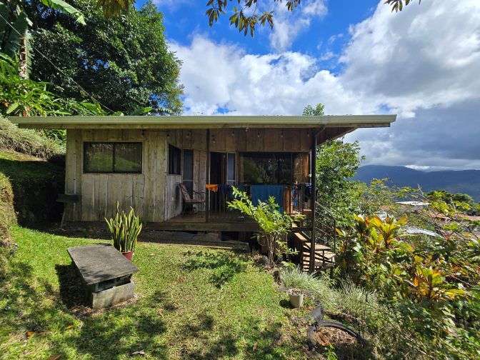 A rustic wooden cabin at Cabana Aromas del Campo in lush green environment, 2026