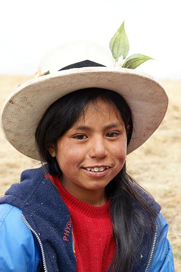 A young student with a with a flower-strewn hat at a school picnic, Hatun Machay, Cordillera Negra 2008