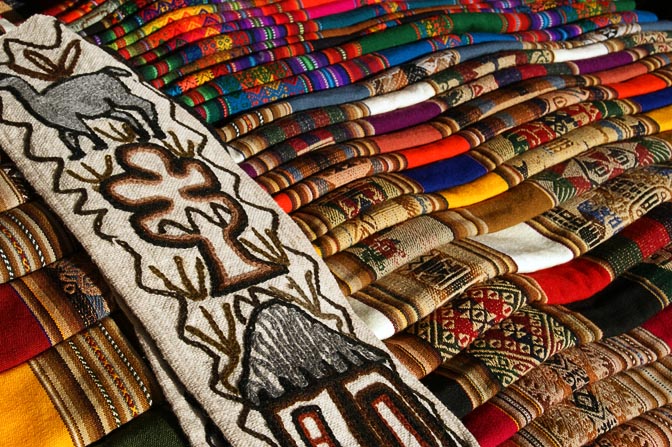 Colorful woven fabrics on a market stand, Pisac 2008