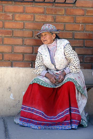A Chola (local woman) sitting on a bench on main street, Cabanaconde 2008