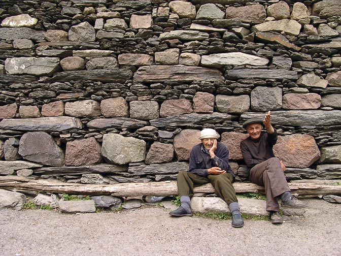 Two locals sitting on a log in Kazbegi, South Ossetia 2007