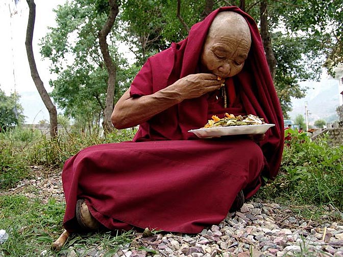 Tibetan nun, eat her lunch at Karmapa birthday celebration, at Gyuto Monastery, Sidmbari, 2004