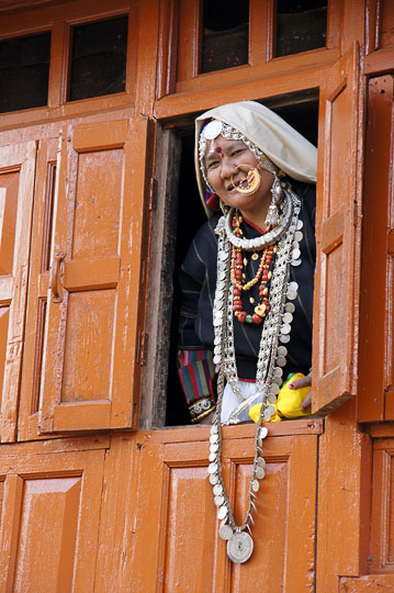 A woman in traditional dress  peering out a window, Roong 2011