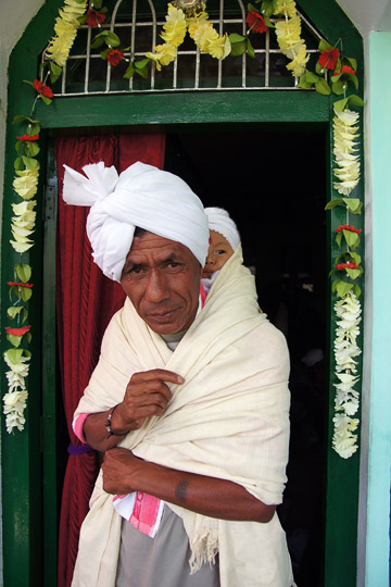 The grandfather is carrying Coco during the traditional puja ceremony on behalf of his birth, Pangu 2011