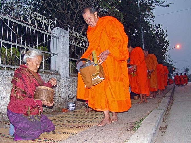 Local women giving alms to the monks very early in the morning, in a Buddhist regimented ritual of 'making merit, Luang Prabang 2007