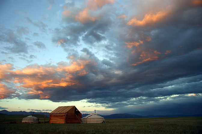 Family Gers (Mongolian home tent) and a wooden hut near Renchinlkhumbe at sunset, North Mongolia 2010