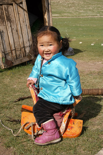 ילדה יושבת על אוכף מונגולי בעמק אורחון, מרכז מונגוליה 2010