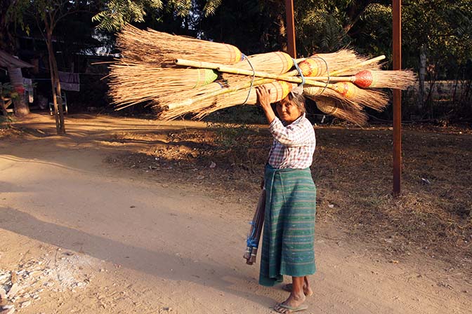 A woman carrying brooms on her head, Bagan 2015