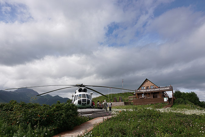 A helicopter and the wooden lodge at Grassy Point, Kuril Lake 2016