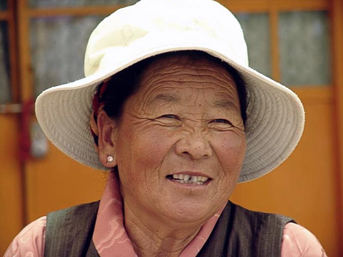 A smiling Tibetan woman at The Dalai Lama birthday ceremony, in the Temple at McLeod Ganj, Dharamsala, India 2004