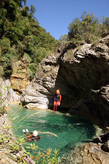 Dudi jumps down a rock-ledge into a clear pool in the Barbaira Canyon, Italy 2011