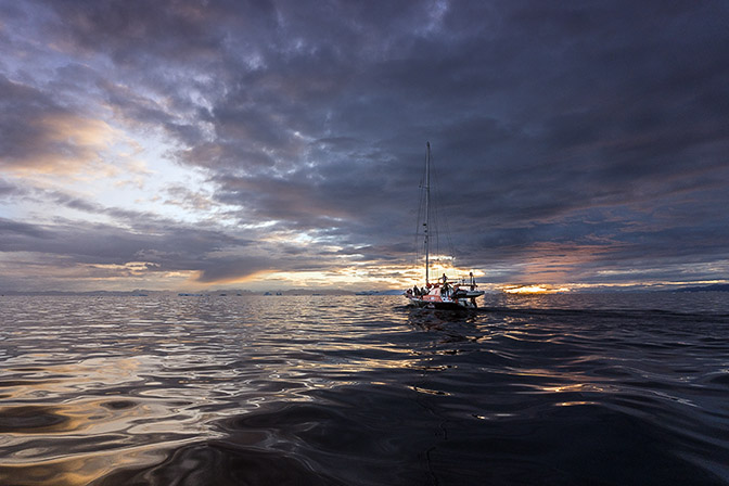 The Peter I yacht sailing at dusk towards icebergs, 2017