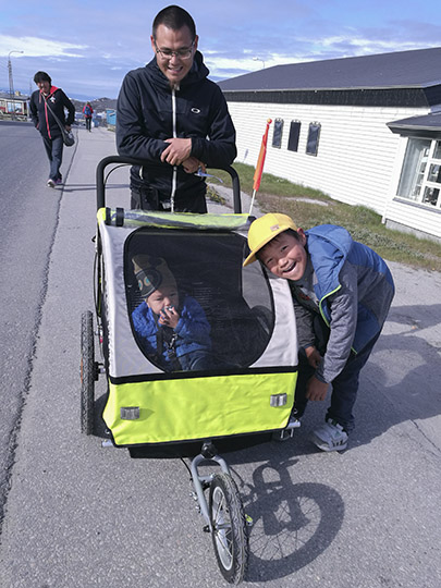 A father pushes a stroller that protects the baby inside it in the harsh weather, 2017