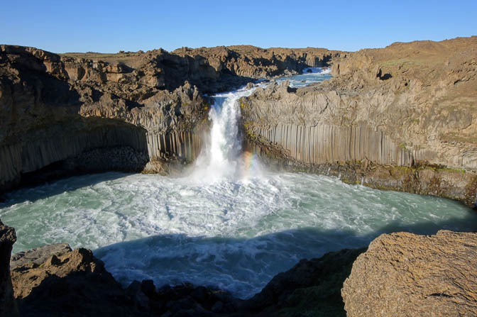 The black basalt columns and a colored rainbow at the white waters of Aldeyjarfoss , 2012