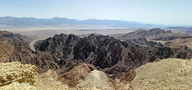 Looking out on Amram Valley, with the black Amram Mountain in the center, from the top of Amram Cliffs, 2021