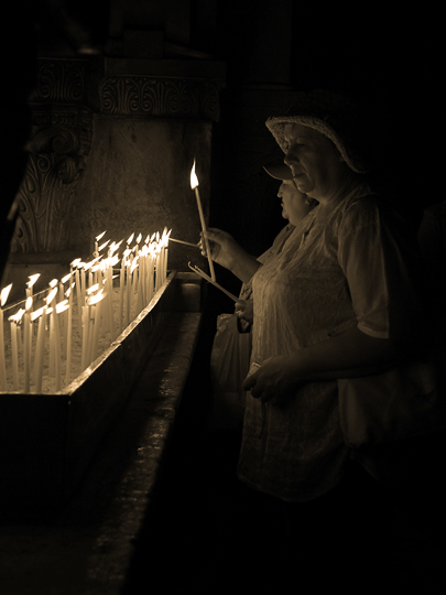 Lighting candles by the Greek Orthodox altar at Calvary, or Golgotha, inside the church of the Holy Sepulchre, The Old City 2010 (Sepia tone)