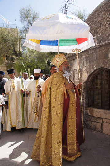 Ethiopian clergymen raising palm branches, surround a structure in Deir al Sultan, on the roof of the Chapel of St. Helena of the Holy Sepulcher, Jerusalem 2012