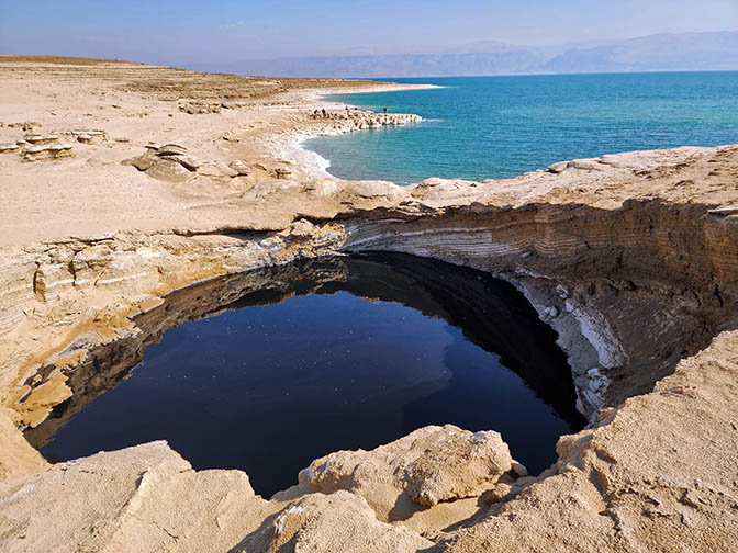 A sinkhole filled with black-blue water north of the Nahal Tamar estuary, 2022