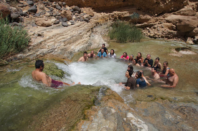 Abdullah slides down the waterfall to the warm pool of Wadi Zarqa Main, 2012