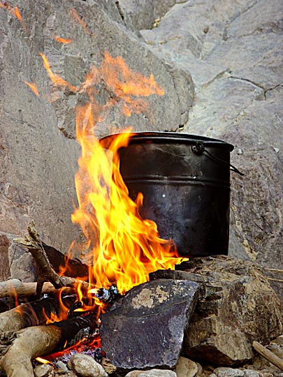 Cooking in a sooty pot on open fire in Wadi Feid, 2003