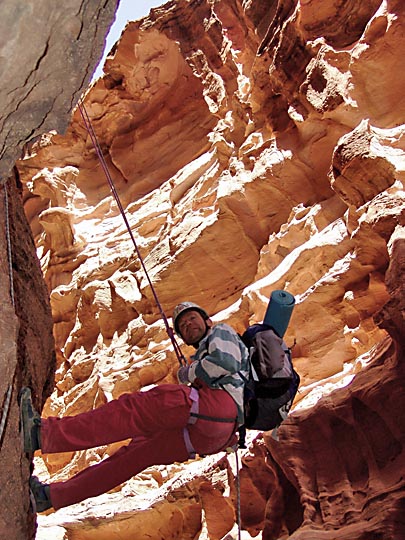 Micha rappels (abseils) down the colorful cliffs of Jabel Rum, 2005