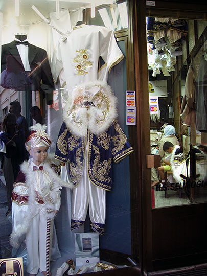 A reticent kid inside a circumcision outfit store, 2003
