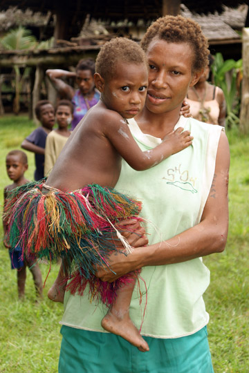 A mother carrying her girl, who is afraid of me because of my white skin, in Kararau, the Sepik River 2009