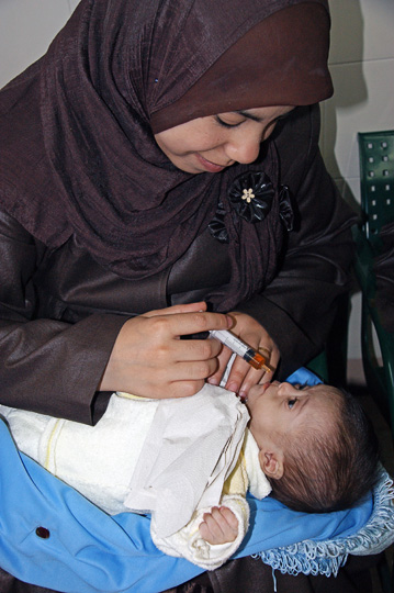 Sami's mother from Gaza instilling mild sedative drug towards echocardiogram test in the outpatients clinic, The Wolfson Hospital 2011